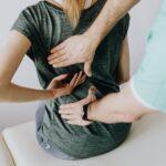 chiropractor placing hands on patients lowerback
