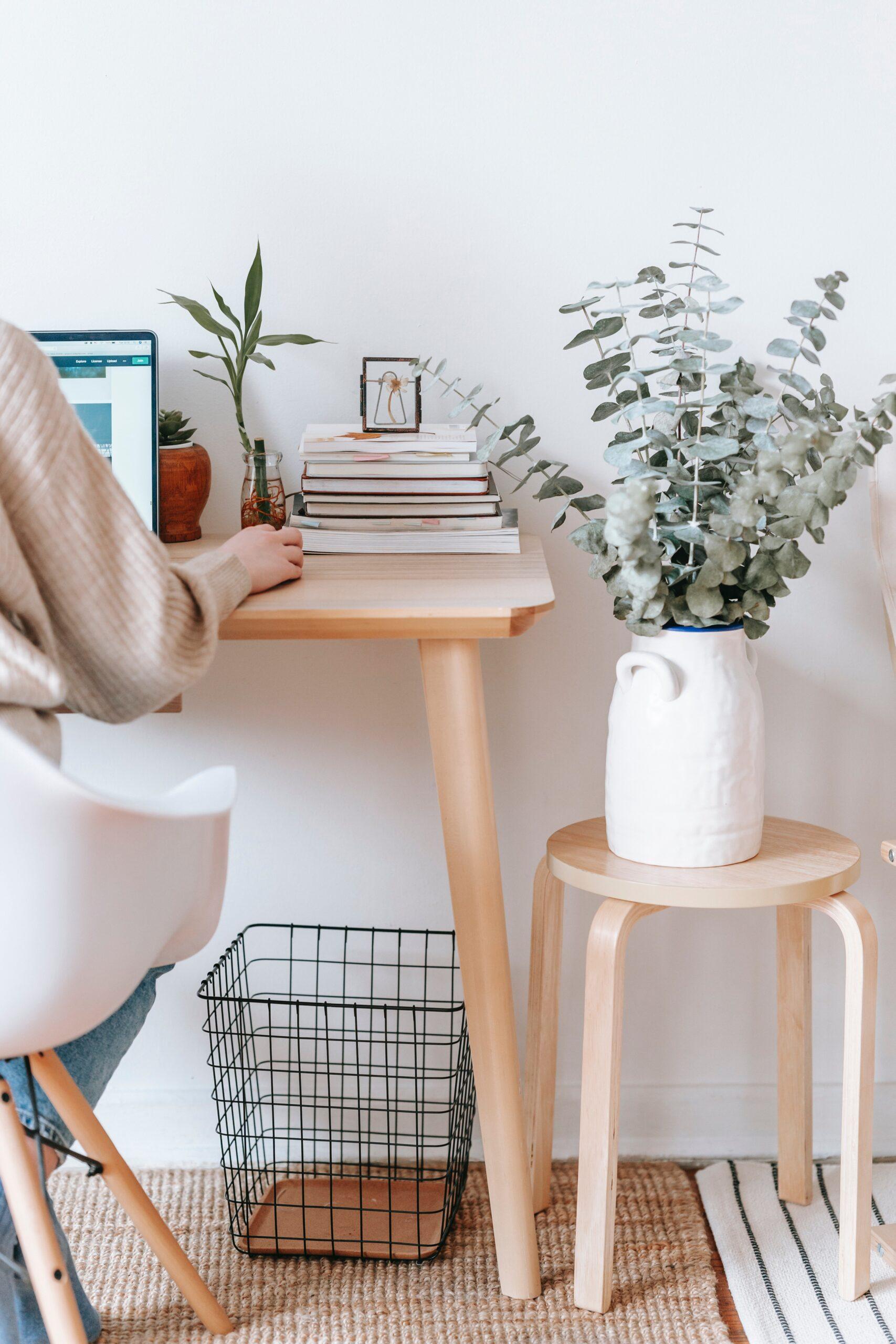 the person sitting at a wooden desk on a laptop