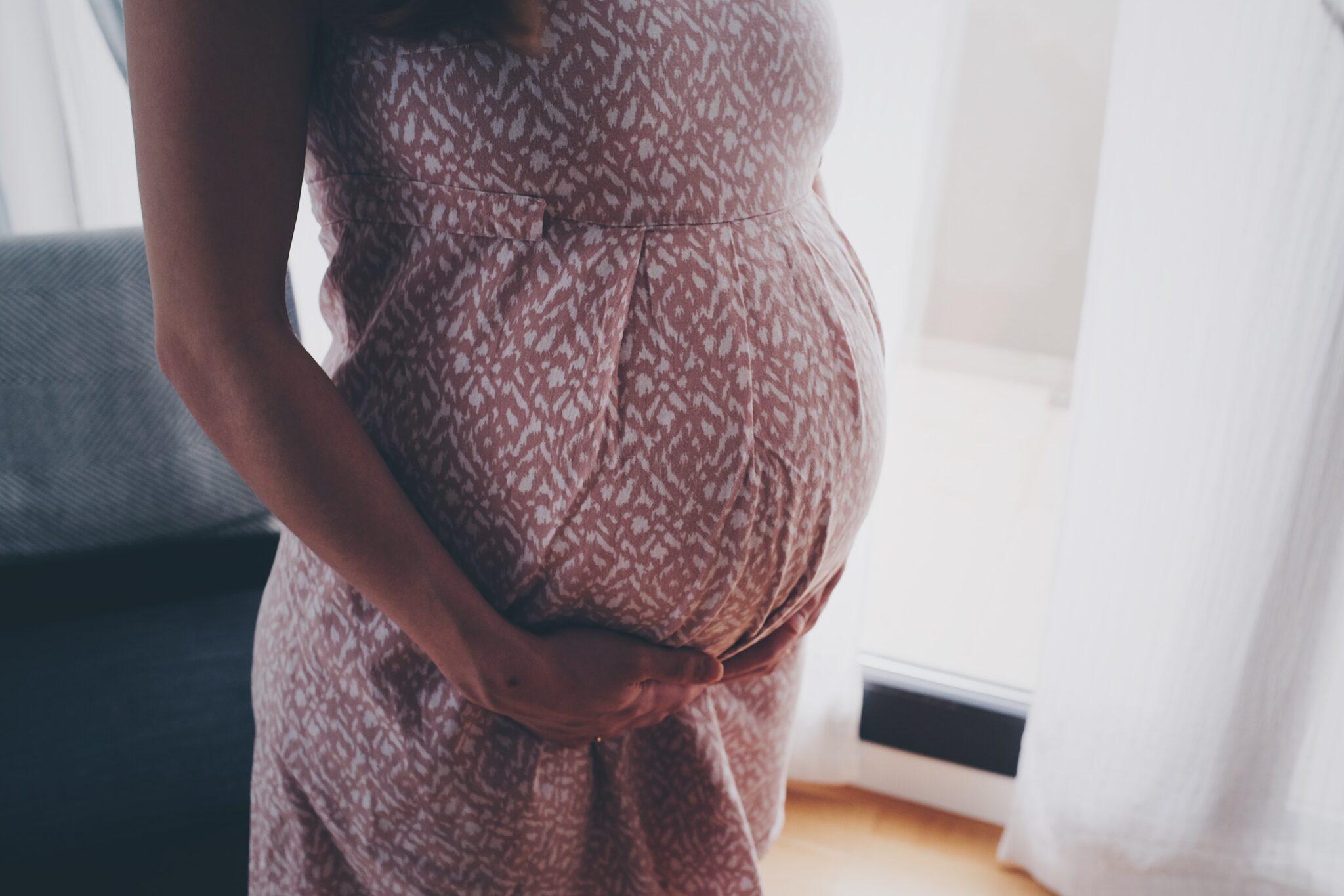 Pregnant woman with her hands on her stomach