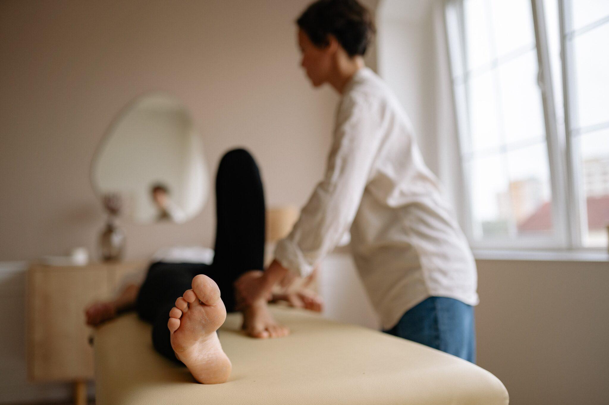 A woman I long sleeves standing beside a patient lying on the bed