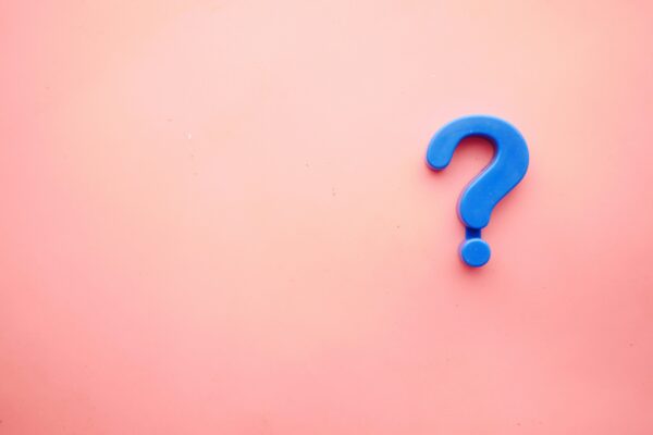 Blue Question Mark Against Pink Background